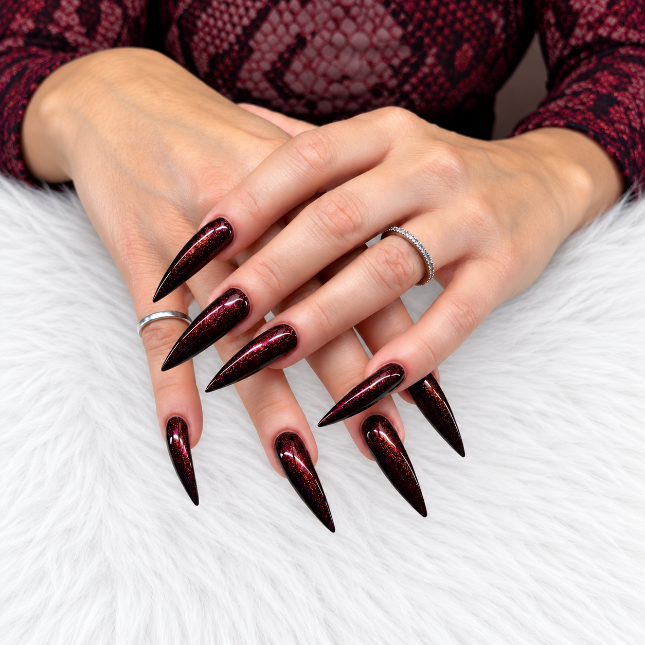 Client wearing Lady LaLa deep burgundy gel polish with copper and fuchsia shimmer on long stiletto nails