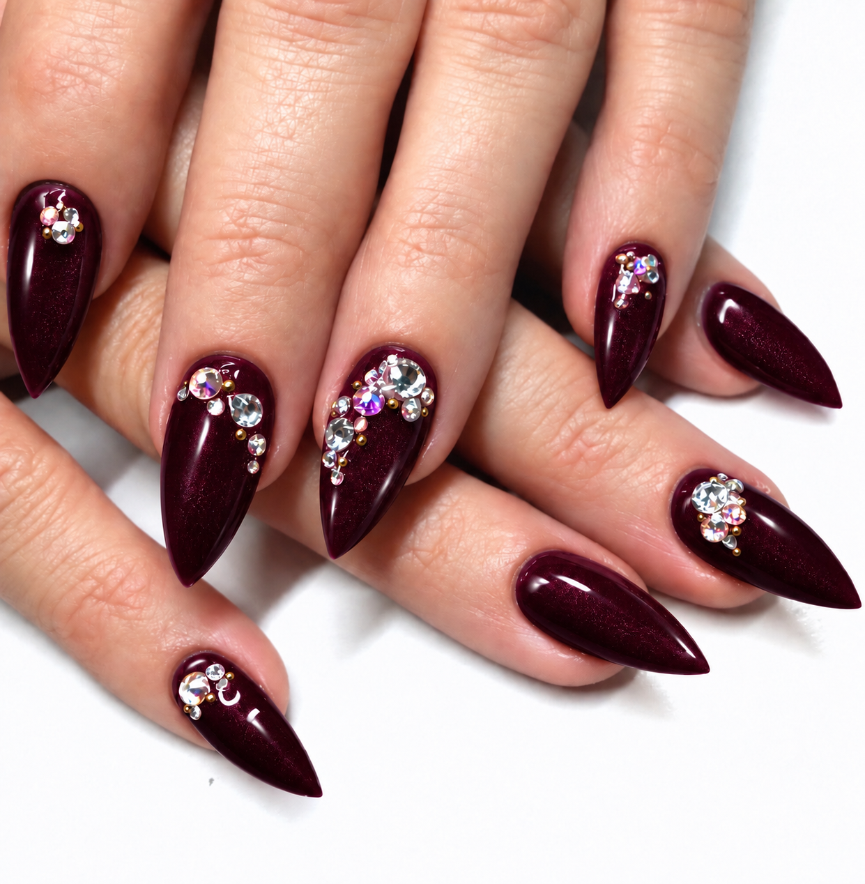 Pointed nails in Naughty Noel deep burgundy gel polish with crystal accents